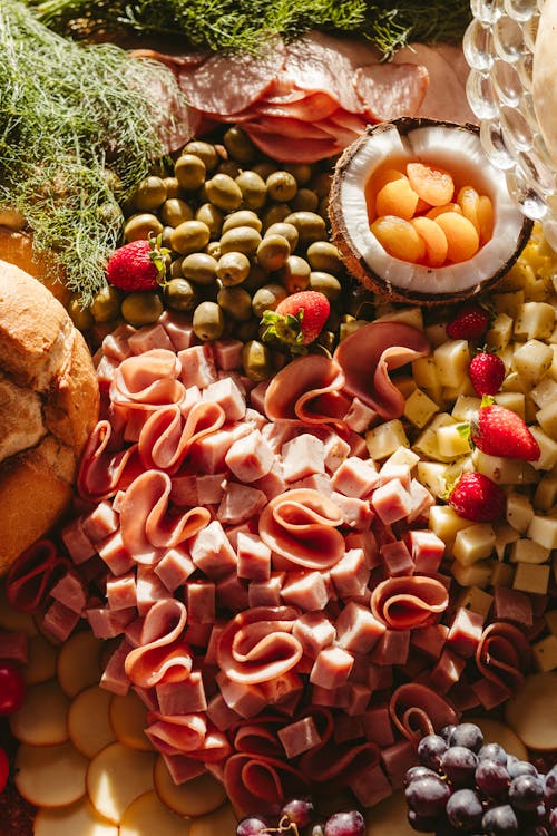 A platter of food with fruit, cheese, and meat