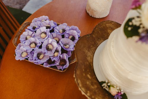 A wedding cake and purple flowers on a table