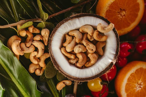 A coconut with cashews and other fruits