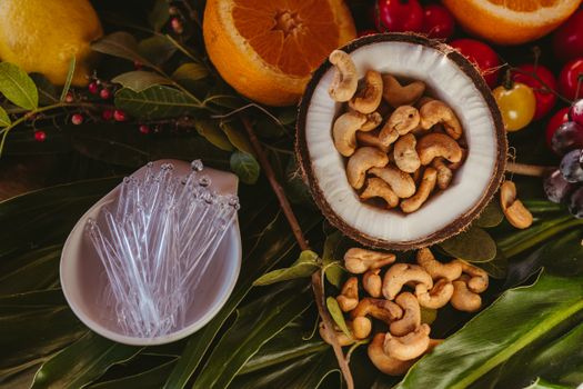 Vibrant flat lay of cashew nuts, tropical fruits, and leaves. Perfect for food photography.