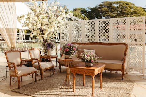 A white tent with wooden furniture and flowers