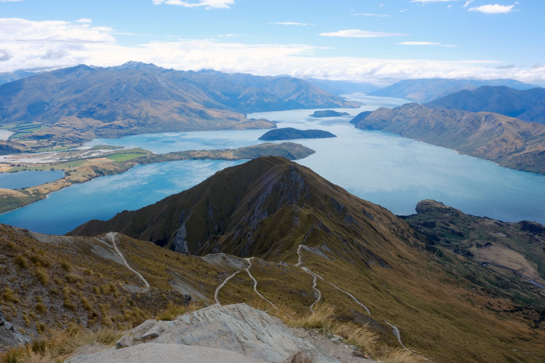 The zig-zagging ridgeline trail of Roys Peak looking down over Lake Wanaka and its islands and mountains