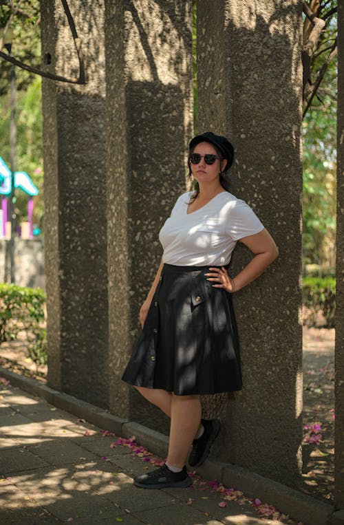 A woman in a white shirt and black skirt posing for a picture