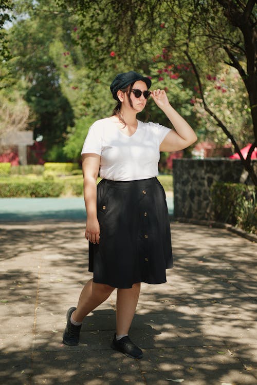 A woman in a white shirt and black skirt