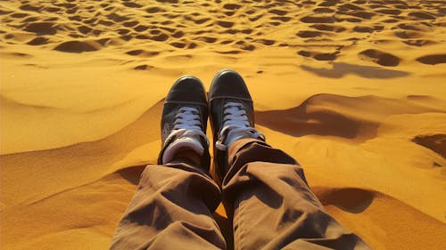 Free Man Sitting on Sand Stock Photo