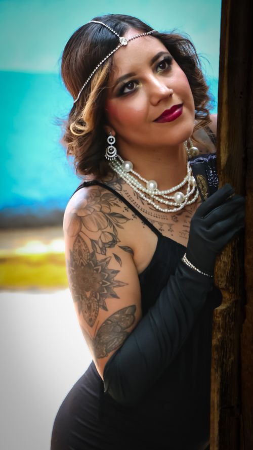 Free Elegant portrait of a woman in vintage attire and tattoos, capturing retro glamour. Stock Photo