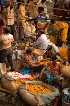 A busy Indian market scene showcasing vibrant flower stalls and traditional shopping activities.