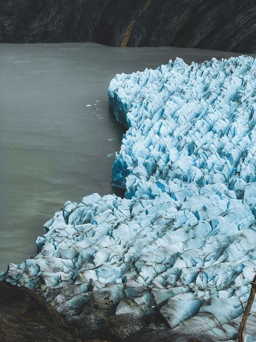 Free A breathtaking aerial view of a glacier meeting a lake in Chilean Patagonia. Perfect for travel and nature themes. Stock Photo