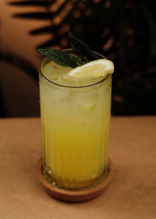 Free Chilled lemon beverage in a glass garnished with mint leaves, perfect for summer. Stock Photo