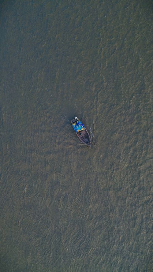 Free Drone shot of a motorboat in the sea near Hatia, Bangladesh, showcasing a serene seascape. Stock Photo