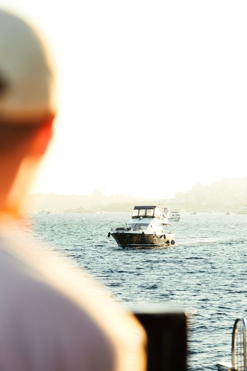 Free A person gazes at boats on the Bosphorus in Istanbul, capturing a tranquil dawn scene. Stock Photo