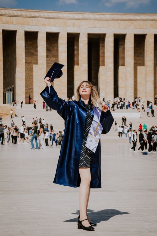 Free Woman celebrating graduation in navy blue gown at Anıtkabir, Ankara. Stock Photo
