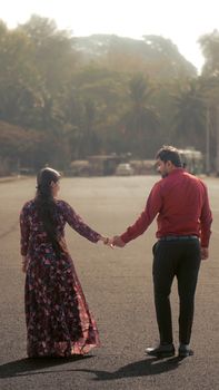 Couple walking hand in hand on city street, embodying love and companionship.