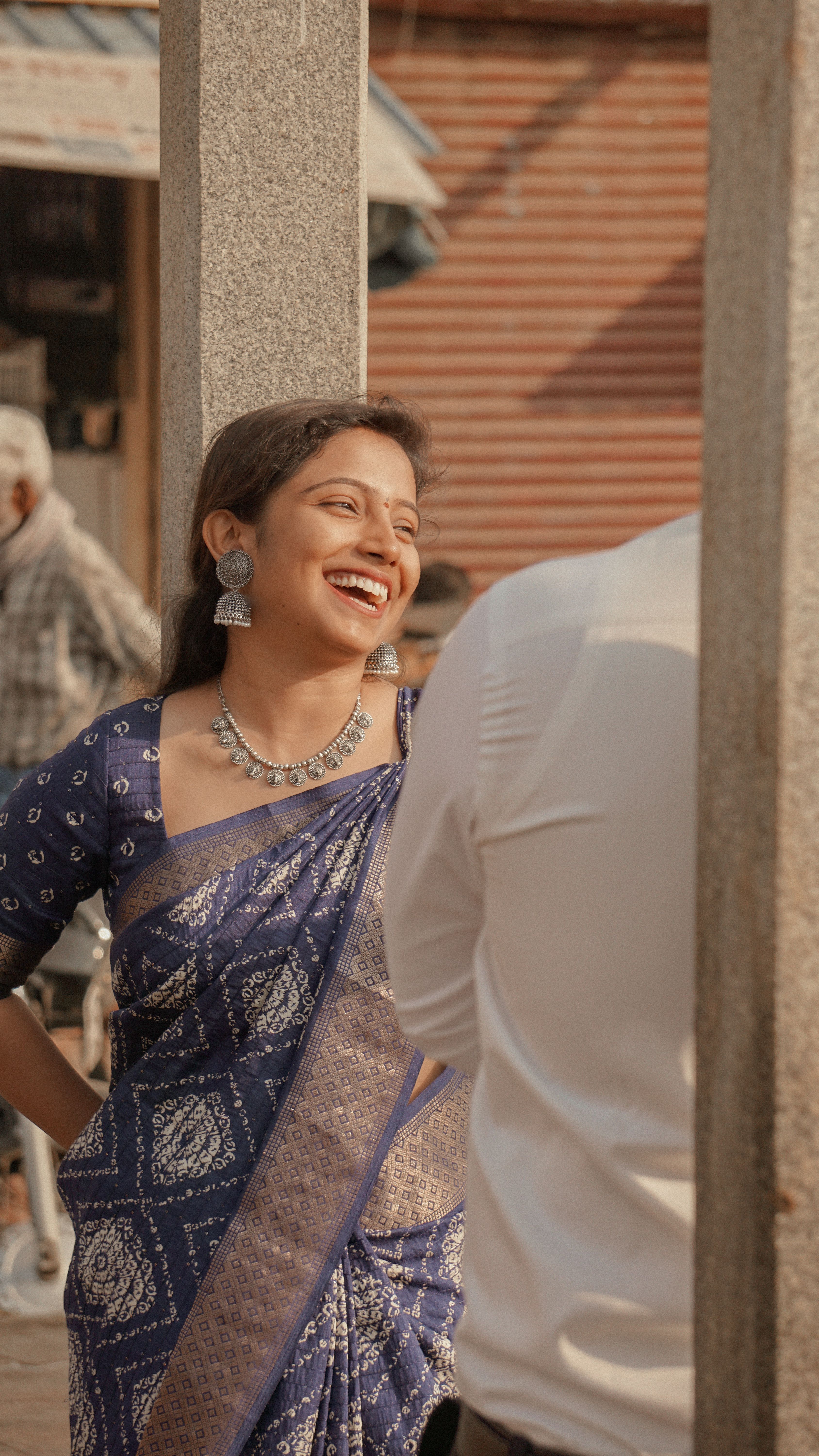 A happy Indian woman in traditional clothing shares a joyful moment outdoors, symbolizing culture and happiness.