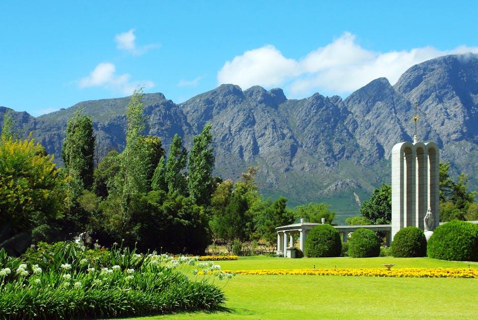 A scenic view of the Huguenot Monument in Franschhoek with lush gardens and mountain backdrop.