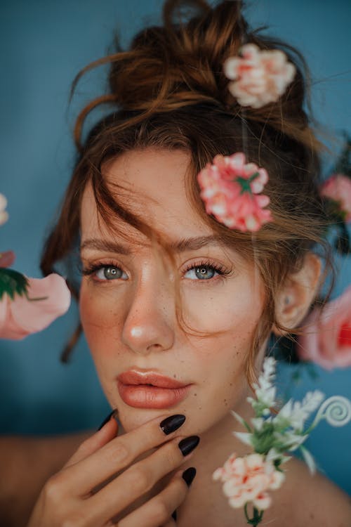 A woman with flowers in her hair posing for a portrait