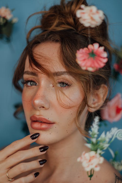 Gratis stockfoto met blauwe achtergrond, bloemen, bruin haar