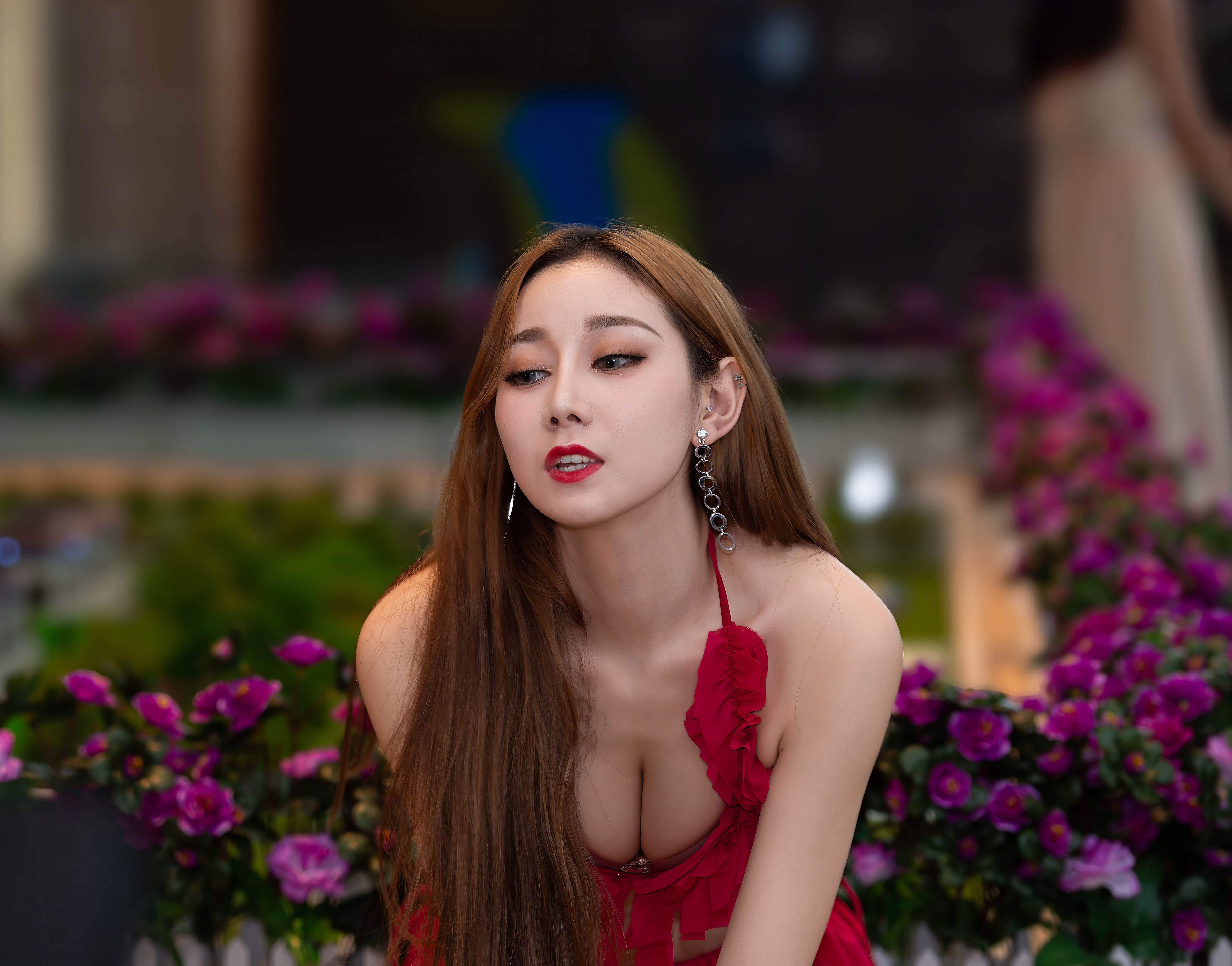 Stylish portrait of a woman in a red dress with purple flowers, highlighting elegance and beauty.
