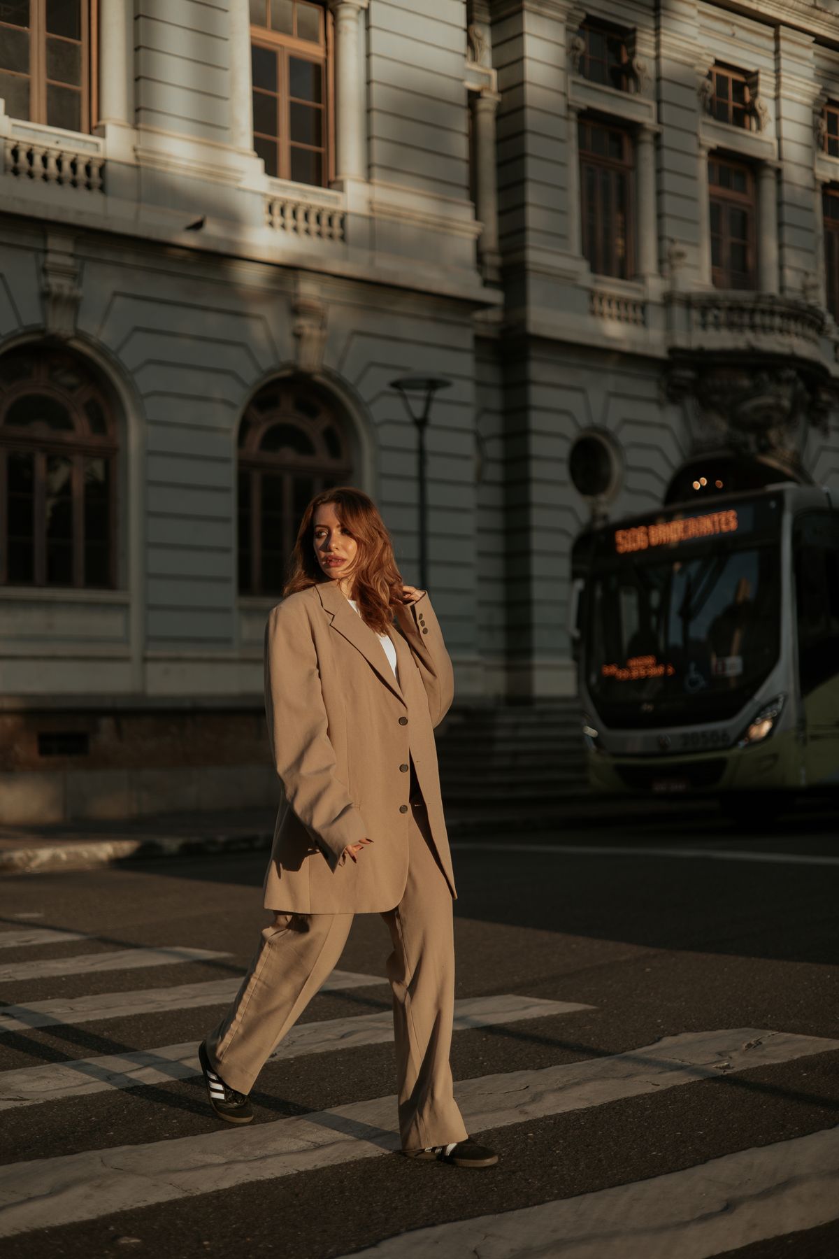 An elegant woman crossing a city street in tailoring — summer suiting in motion