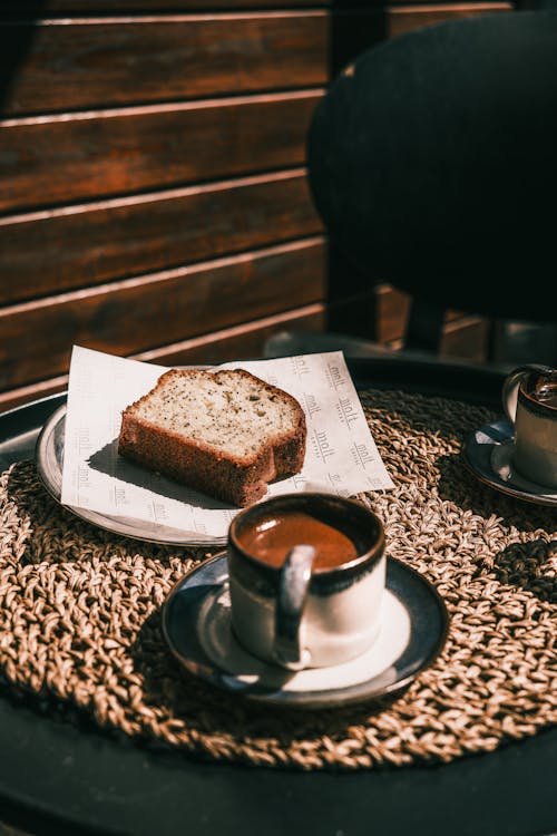 A coffee and a slice of bread on a table