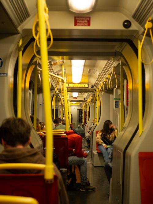 Free Passengers seated inside a subway train during nighttime travel, showcasing public transportation. Stock Photo