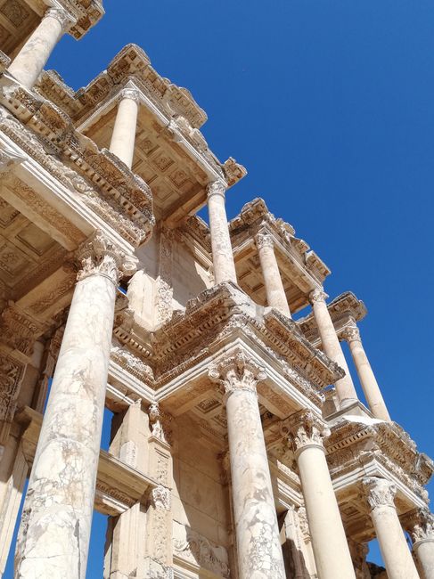 Capture of the Library of Celsus' classical Roman architecture against a clear blue sky.