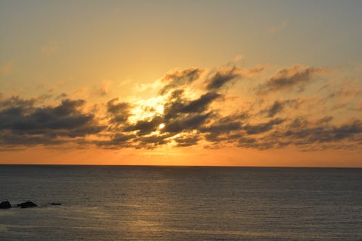 A stunning sunset over a calm ocean with vivid clouds and vibrant colors.