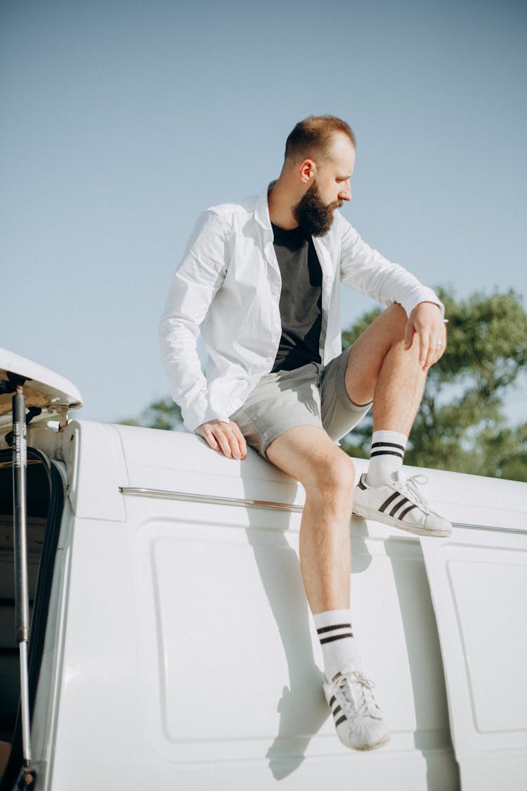 Photo Of A Man Sitting On Top Of A White Van