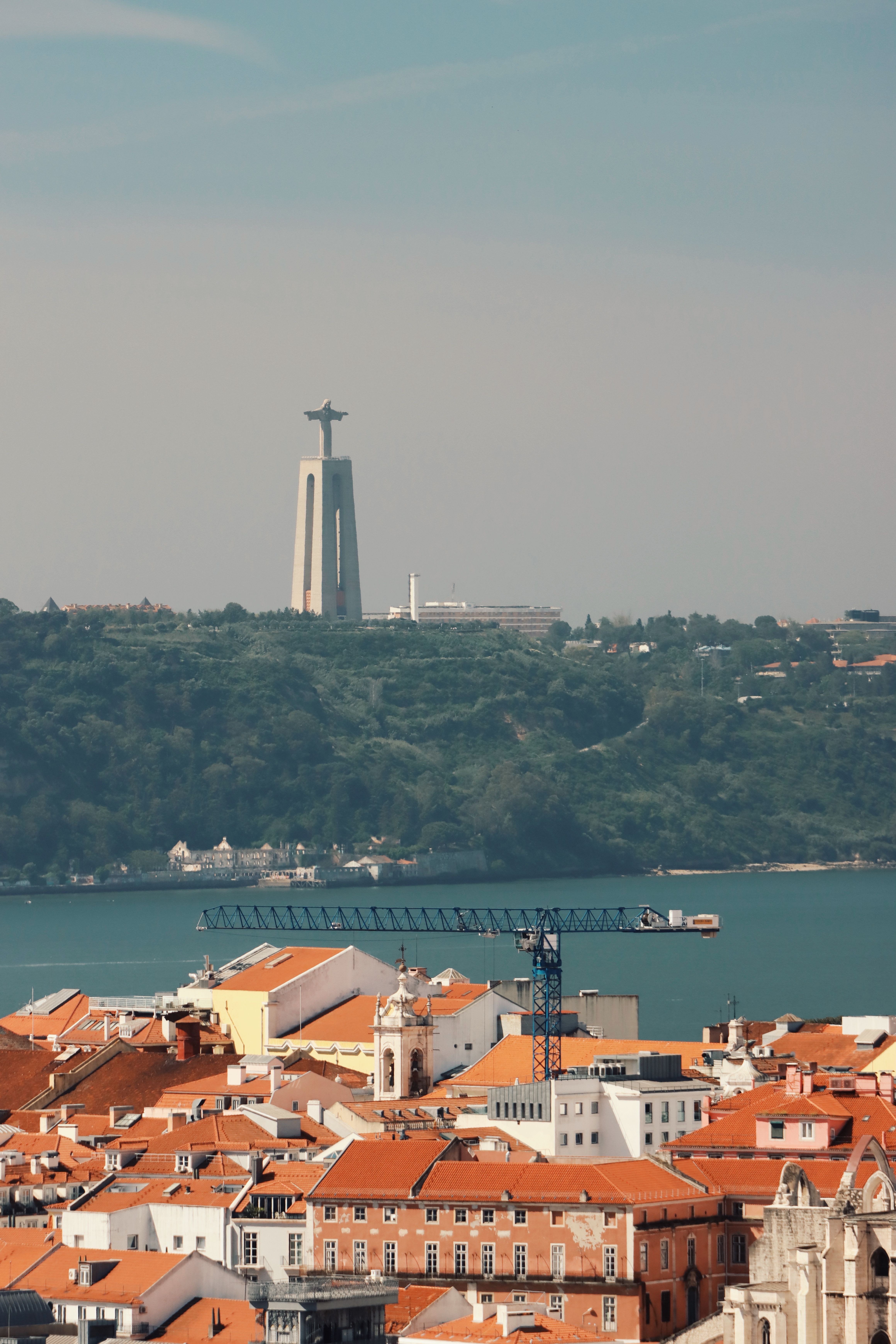 Stunning landscape of Lisbon featuring the iconic Cristo Rei Statue across the Tagus River.