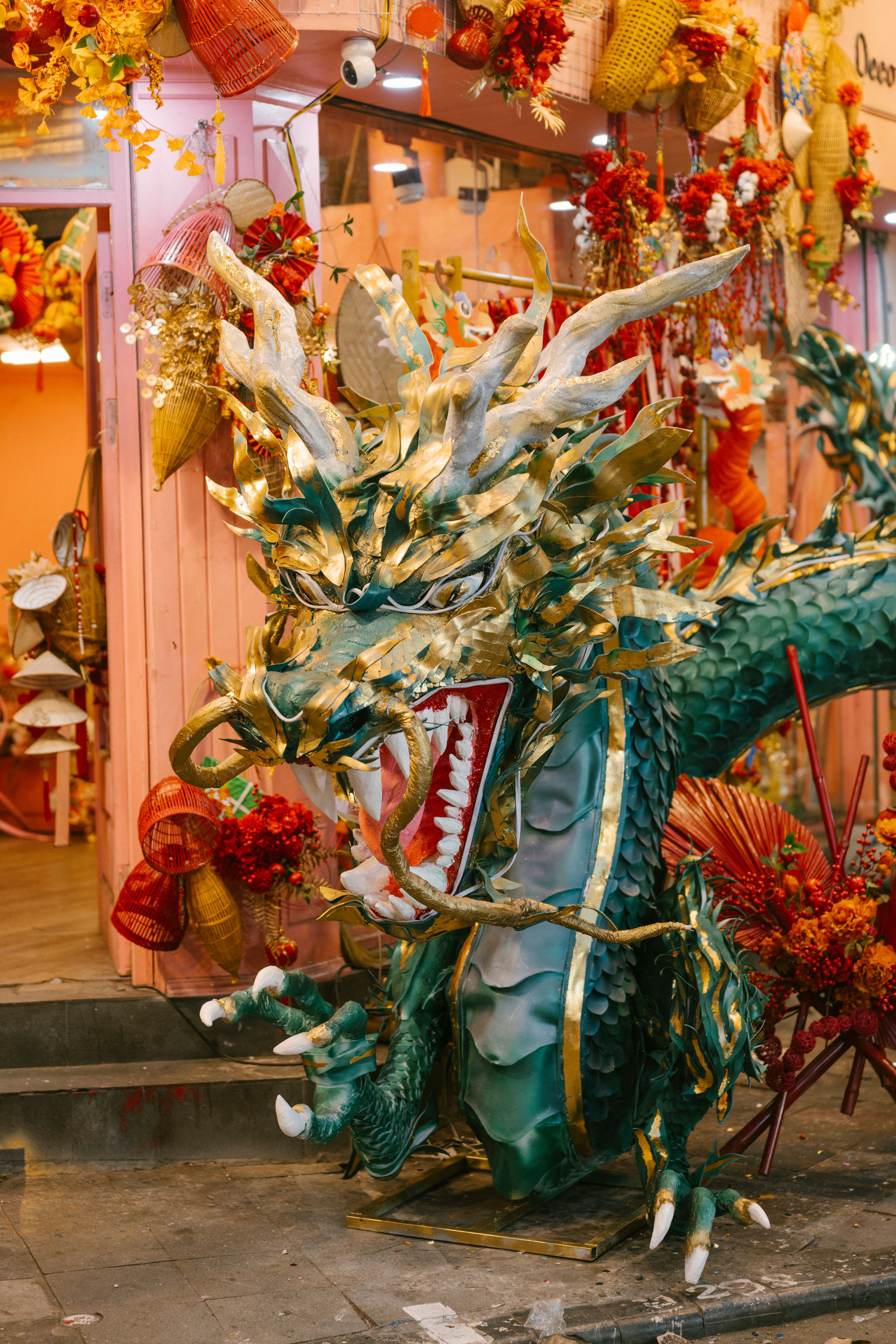 Colorful dragon statue amidst festive decorations in an urban setting celebrating tradition.