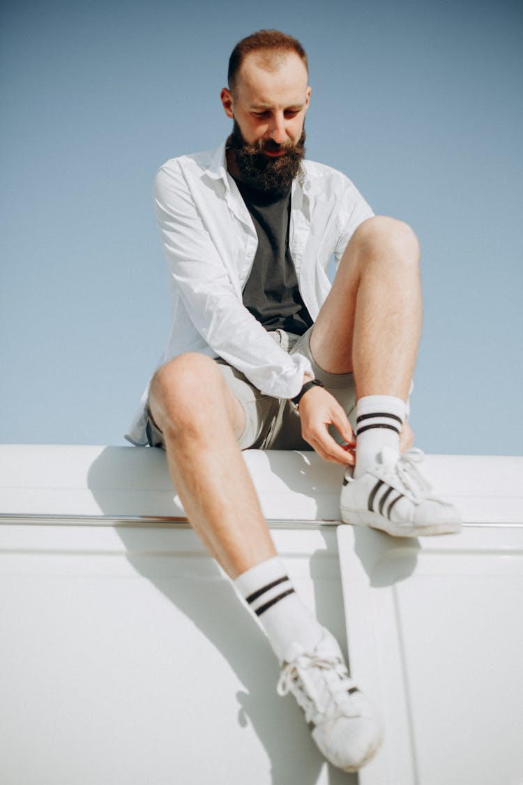 Photo Of A Man Fixing His Shoes