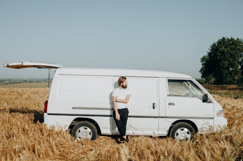 Photo of a Man Leaning on White Van