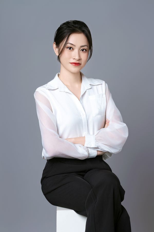 Woman in an ivory satin blouse with black trousers