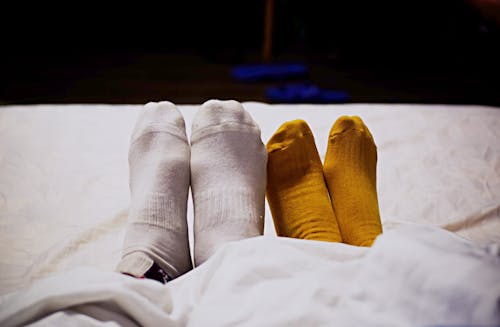 Socks of Two People Lying in Bed