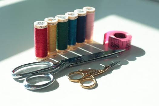 Bright sewing essentials including thread, scissors, and measuring tape.
