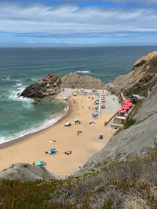 Free Beautiful sandy beach in Silveira, Portugal with colorful umbrellas and clear blue ocean waters. Stock Photo