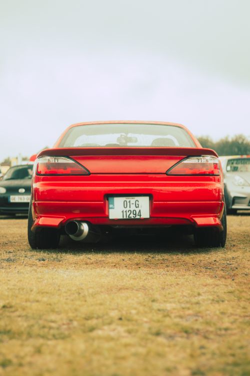 Free Red sports car parked outdoors showcasing rear design and license plate. Stock Photo