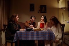 Four people share a cozy evening meal, enjoying togetherness and conversation.