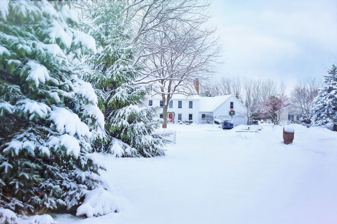 A snowy neighborhood with frosted trees and a cozy house
