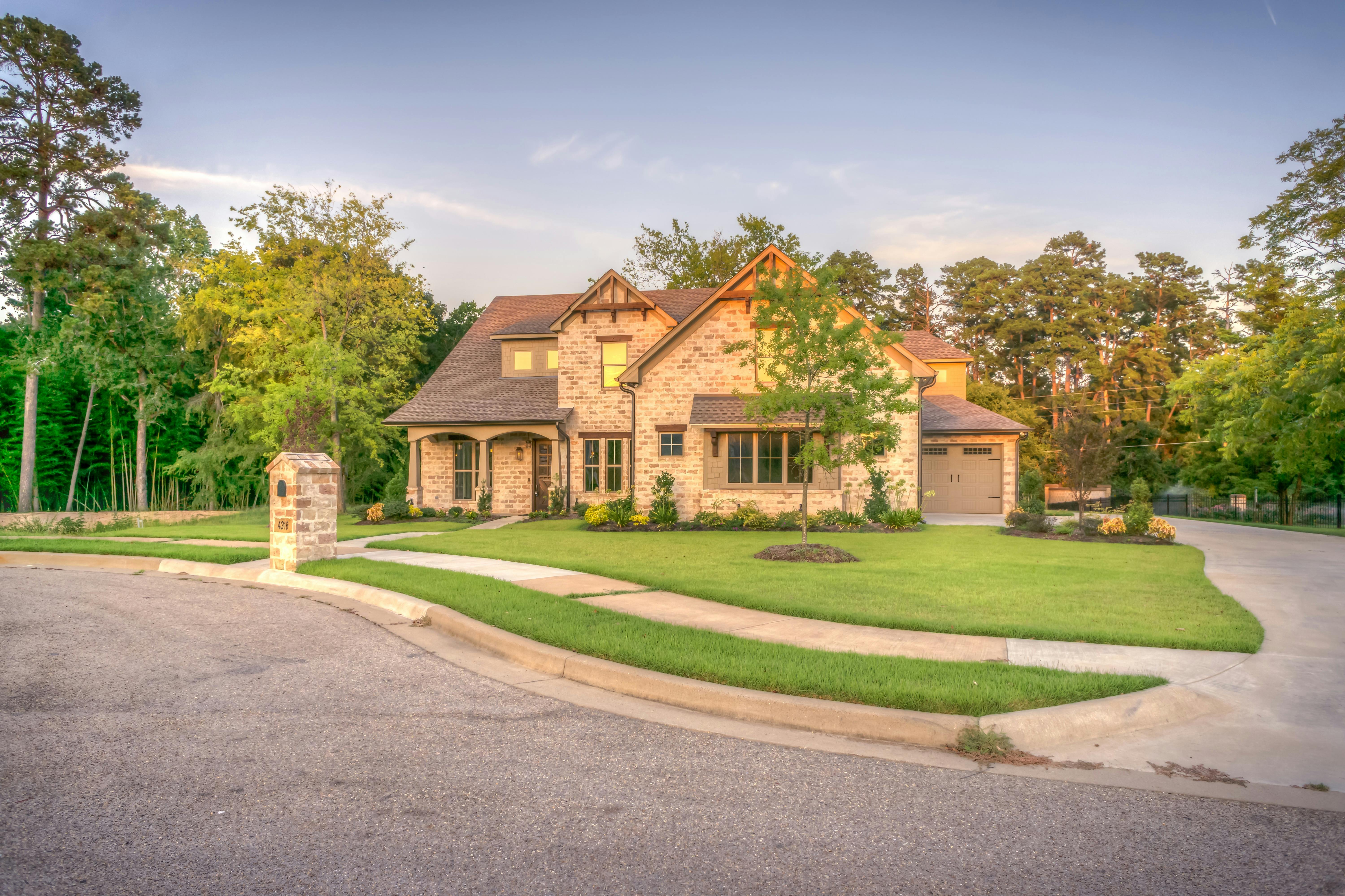A brown brick house surrounded by turf