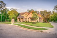 这座优雅的石砌家庭住宅阳光明媚，草坪、树木和车道都修剪整齐