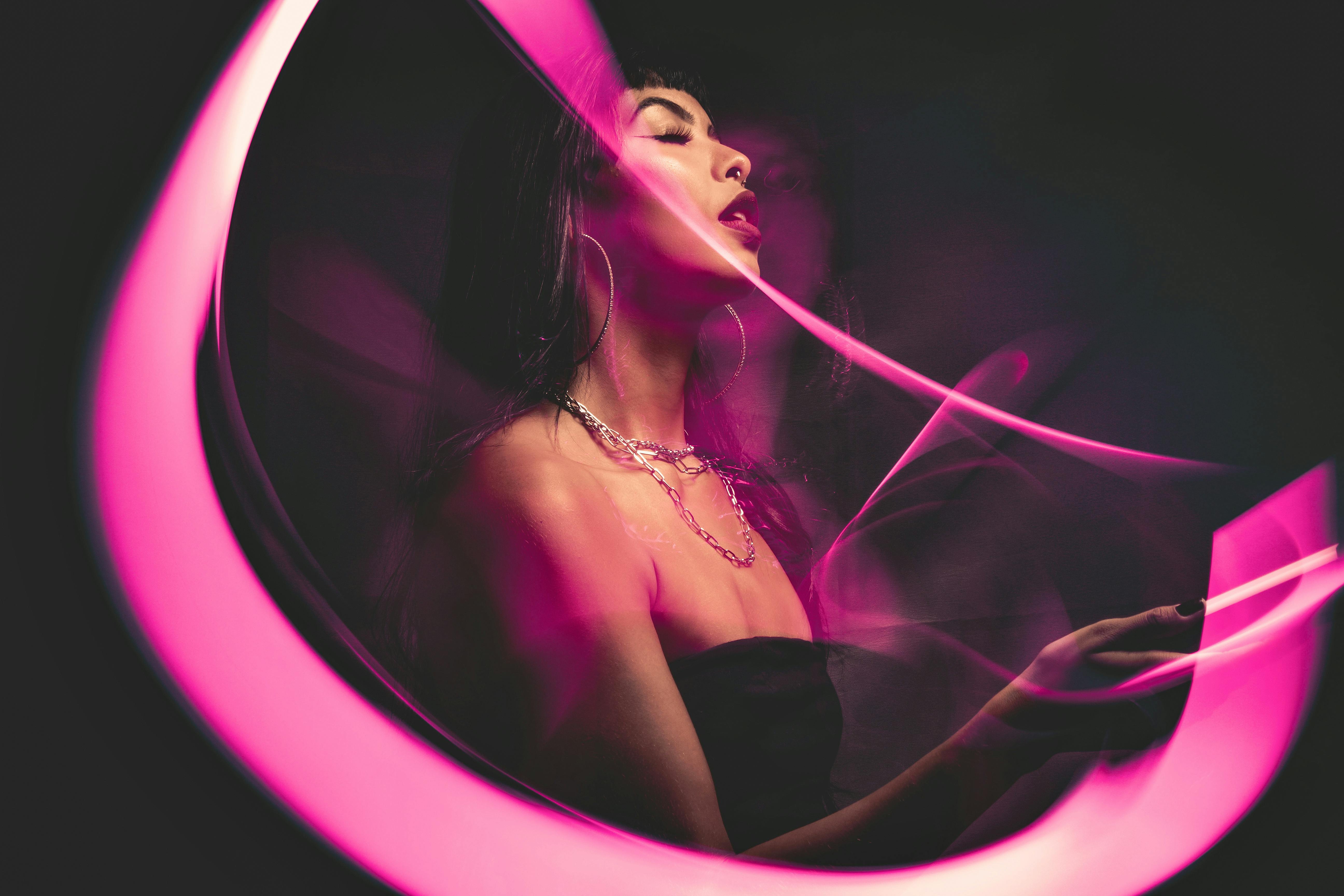 Woman in a fashion portrait with creative pink neon light effects and artistic lighting.