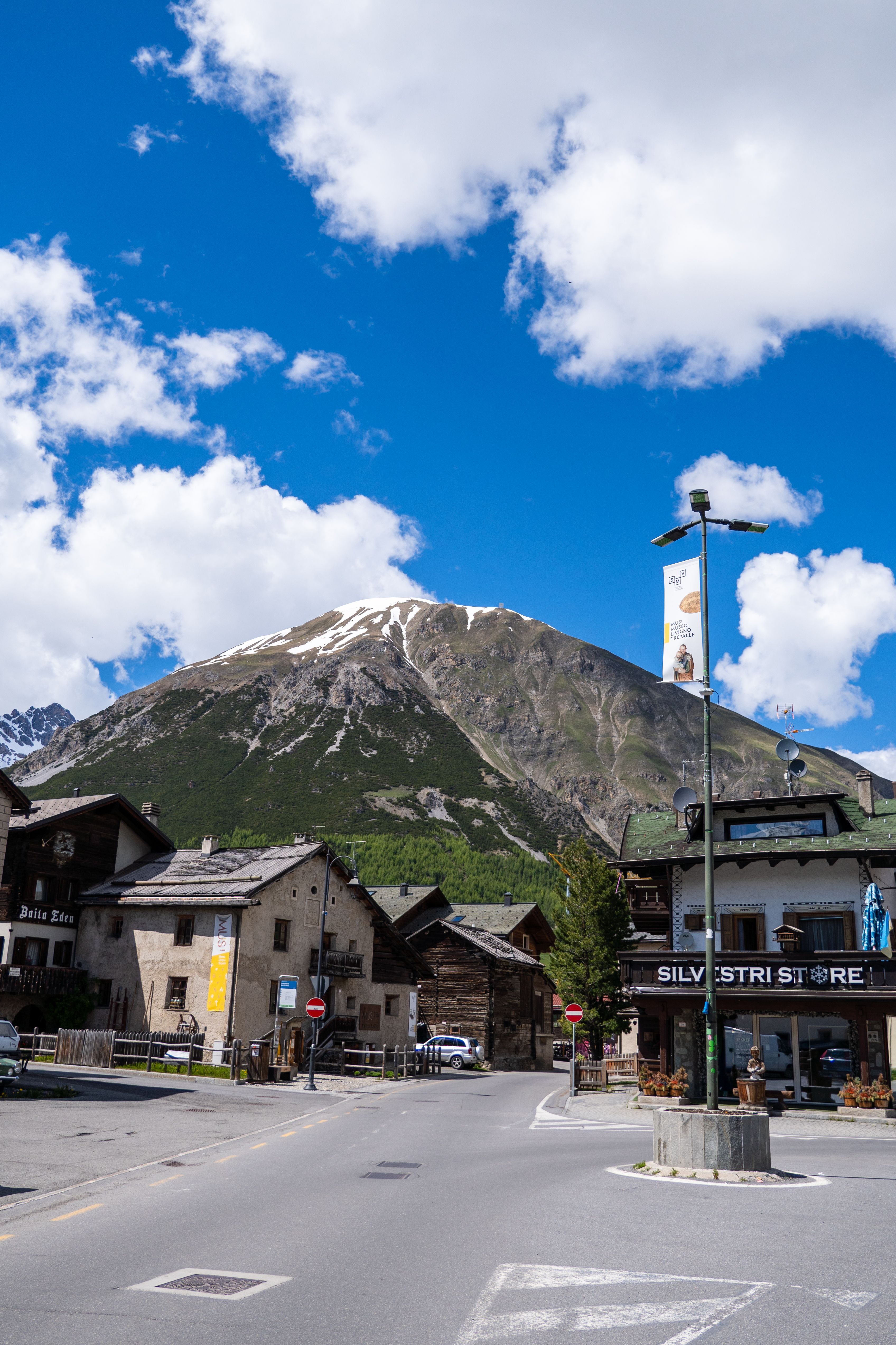 Charming village in Livigno, Italy with snowcapped mountains and blue sky.