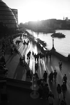 Black and white photo capturing urban silhouettes along the Thames River, London at sunset.