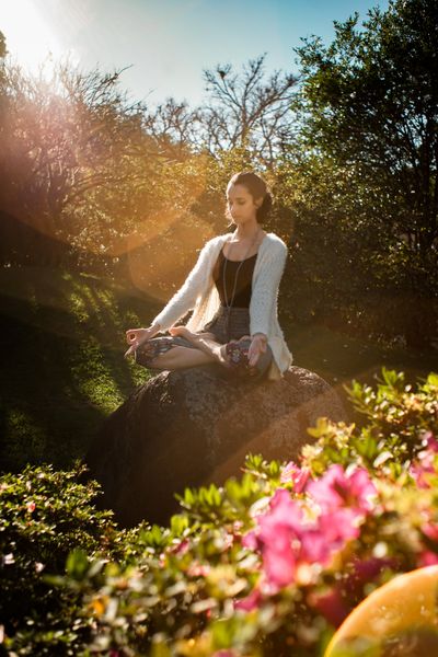 Woman in a tranquil meditation pose outdoors in sunlight — photo by Felipe Borges on Pexels