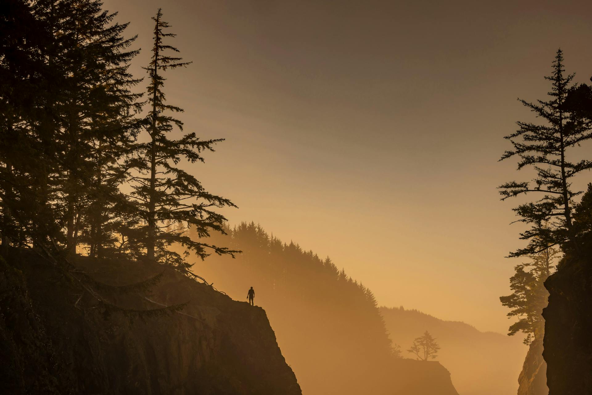 Person Standing on Rocks over Abyss at Sunset