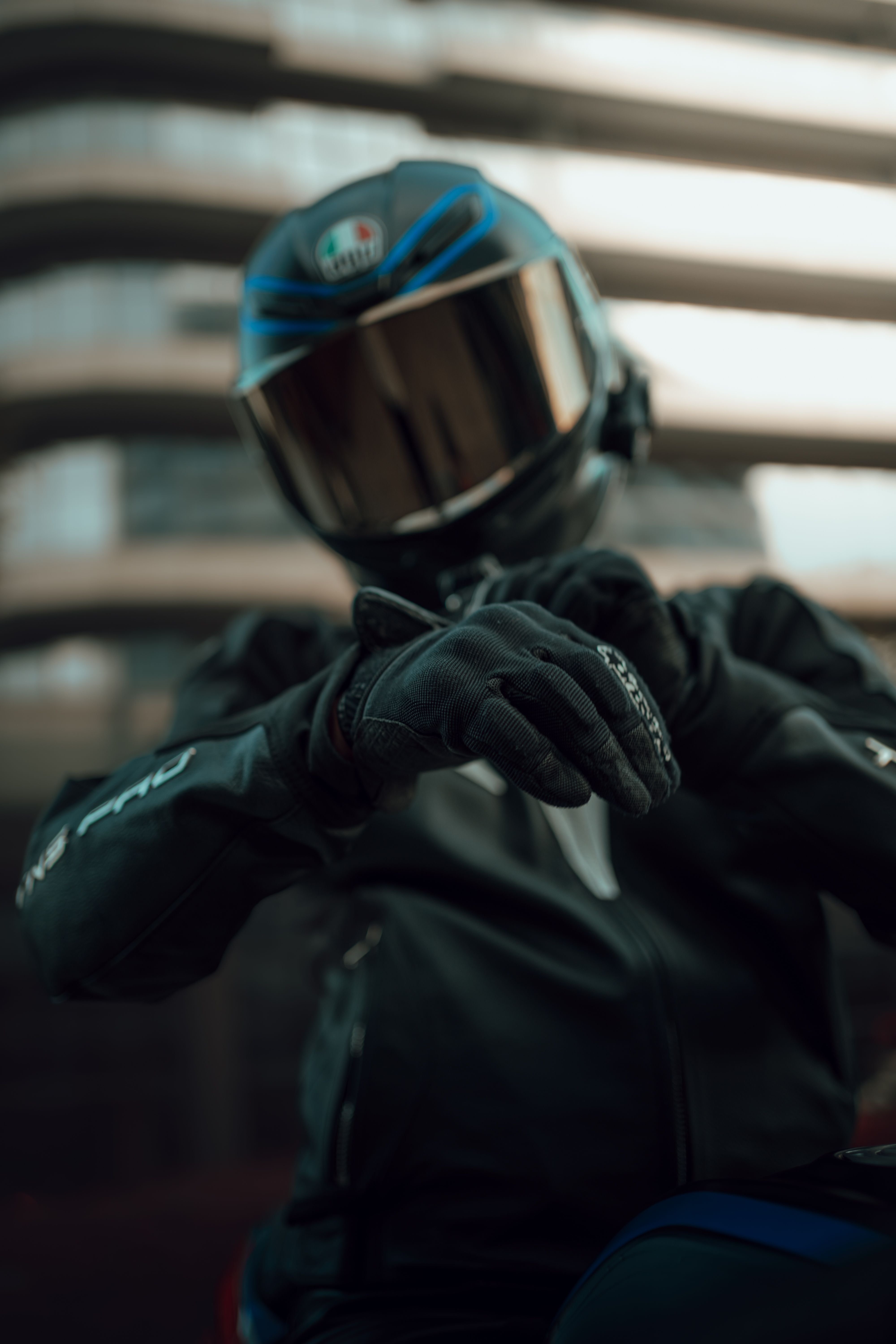 Motorcyclist in full gear posing in an urban environment.