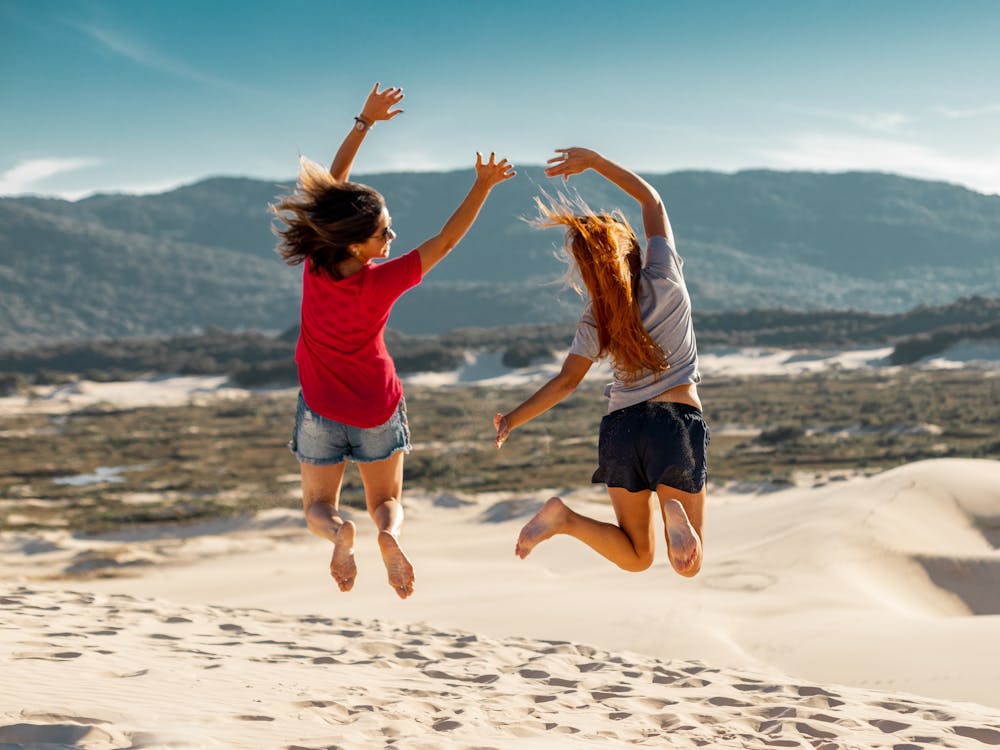 Free Jump Shot Photography of Two Women Stock Photo