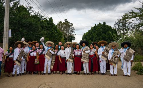 Free Group of adults in traditional Mexican clothing posing on a rural street in Oaxaca. Stock Photo
