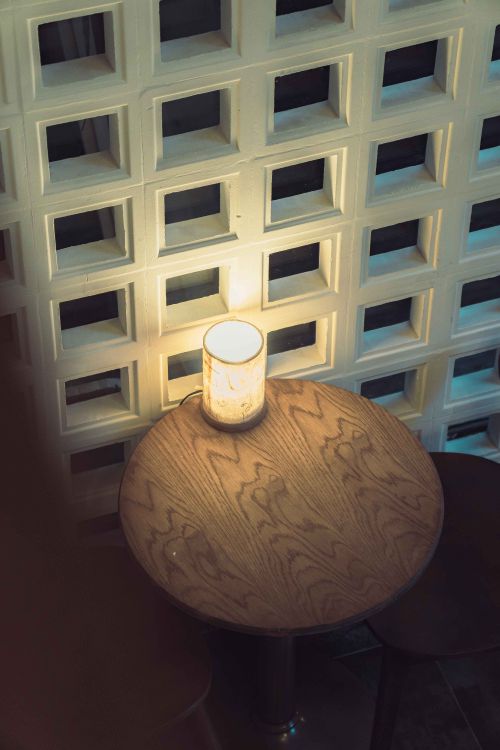 Free Warm-lit table setting at a restaurant in Ho Chi Minh City, Vietnam, with unique wall design. Stock Photo